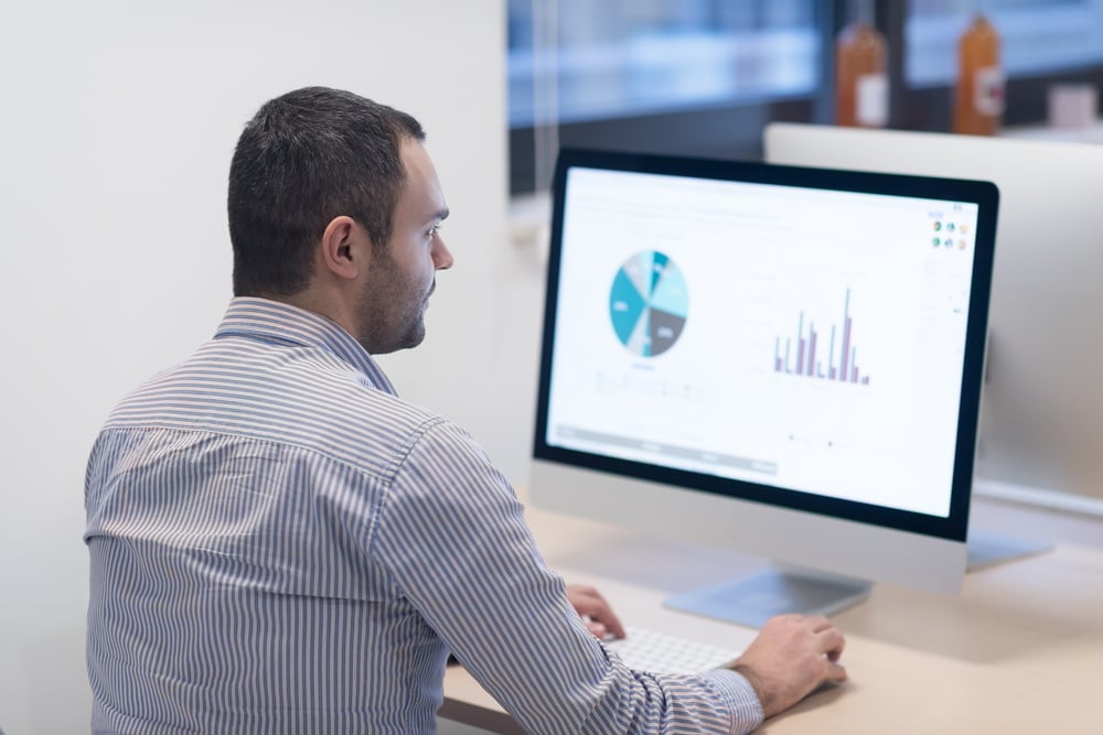 Business Leader Looking at Digital Dashboards powered by Analytics