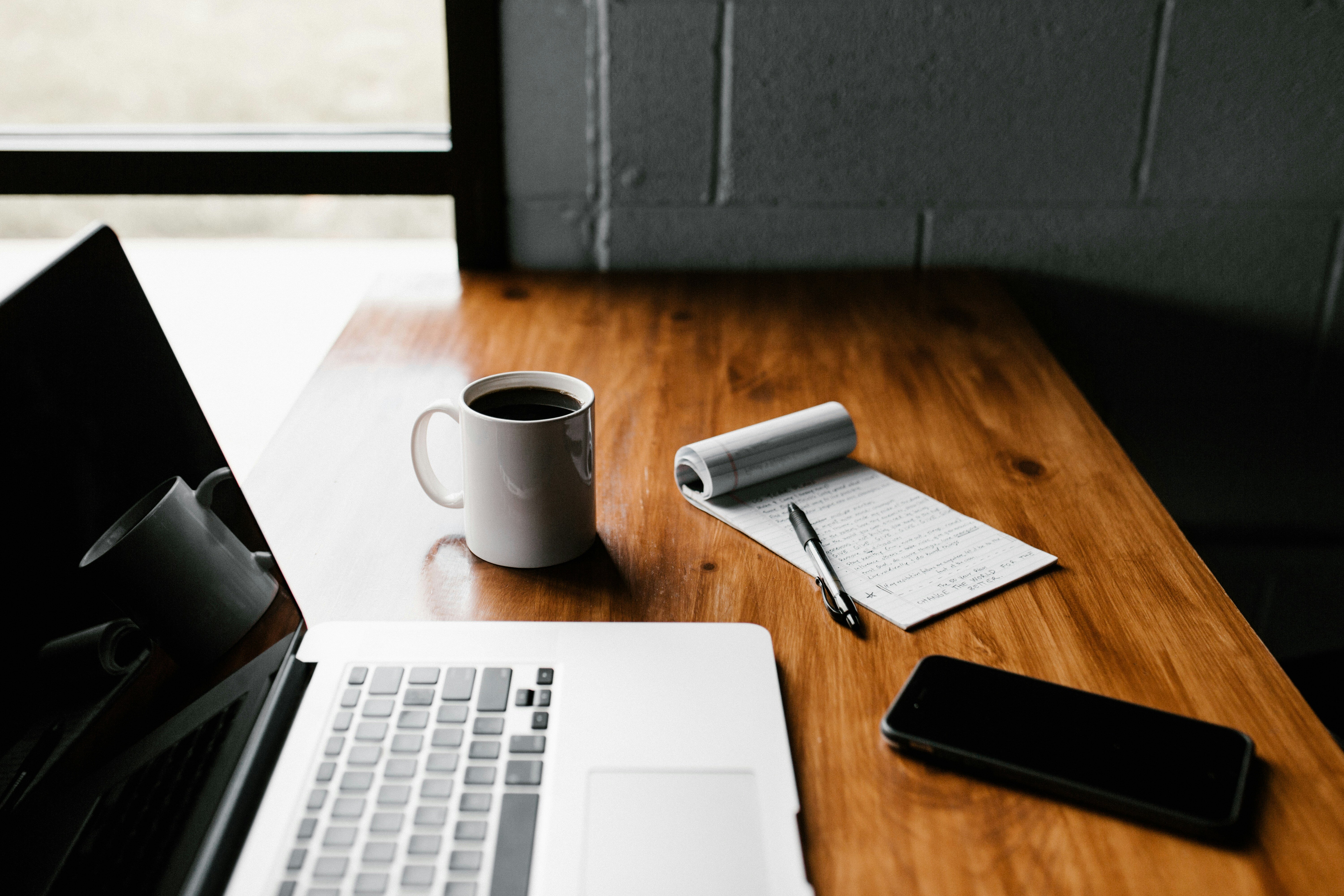 Table with laptop and cup of coffee talking about AI